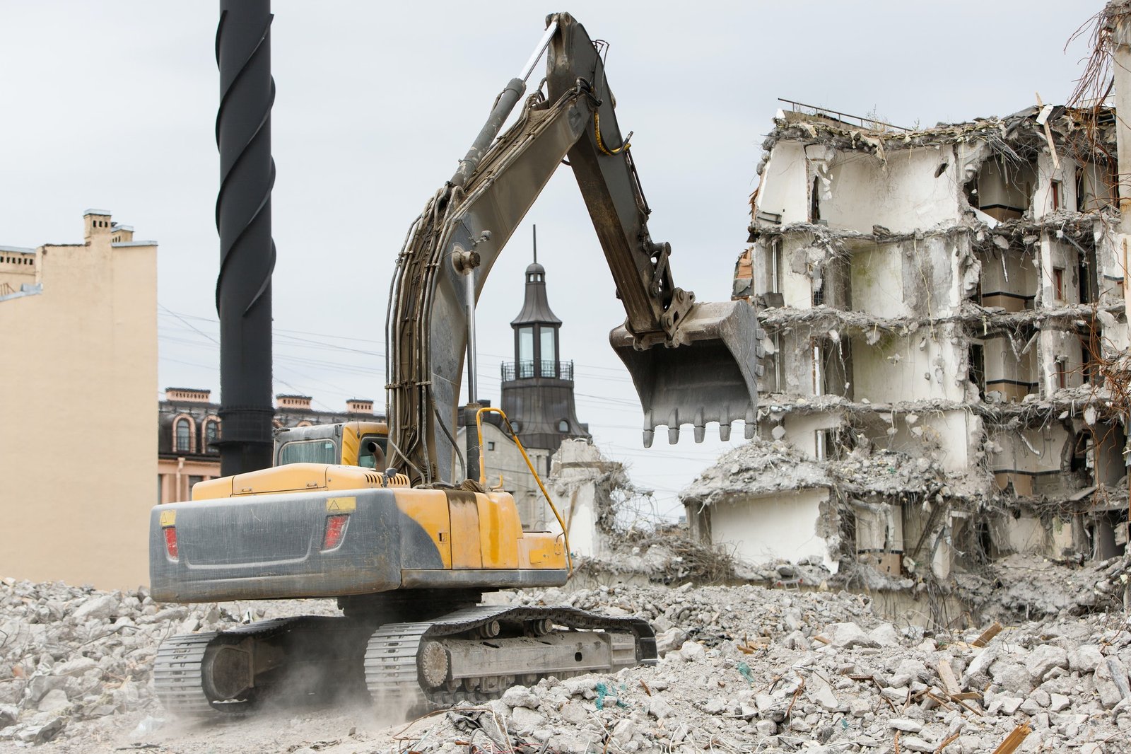 Building of former hotel demolition for new construction using special hydraulic excavator-destroyer