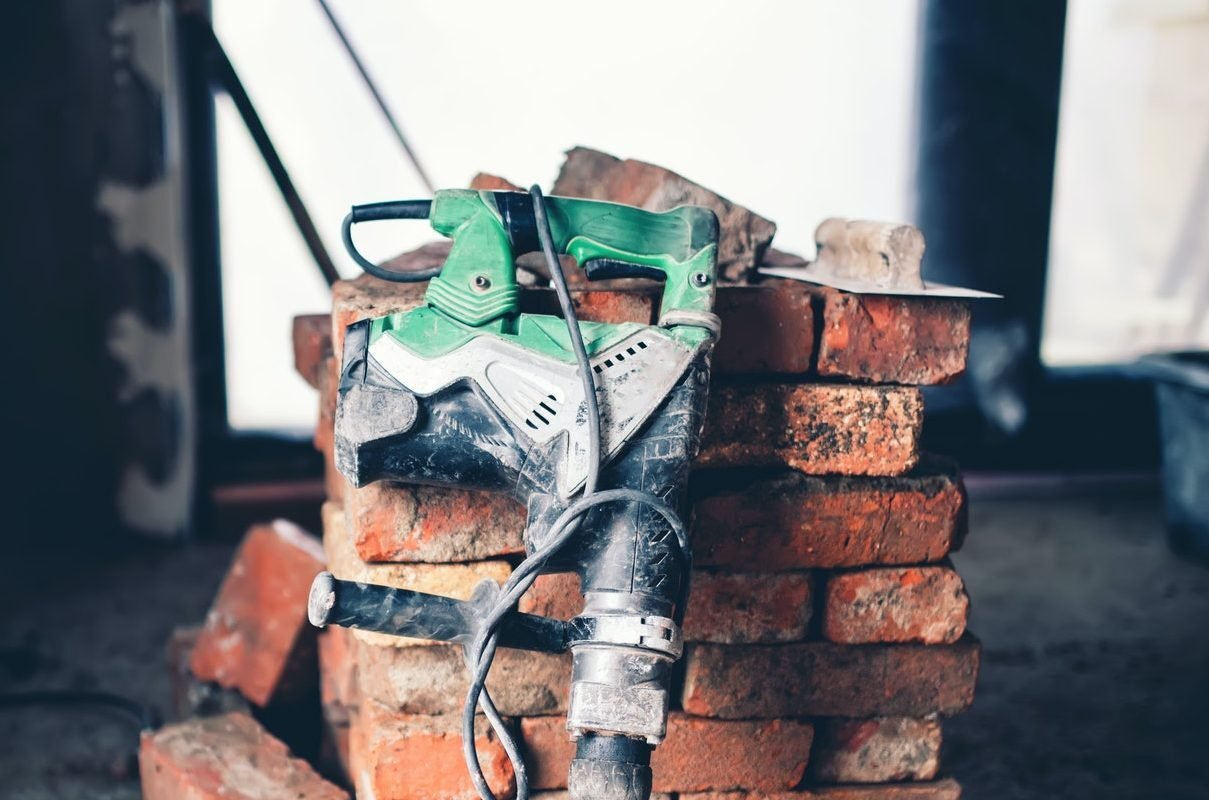 Construction tool, industrial jackhammer with demolition debris and bricks